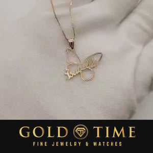 Video of the gold butterfly name pendant turning in the light on a white knit background
