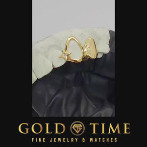 Video of yellow gold open face and solid cap grillz with a North Star gap accent, turned on a dental mold