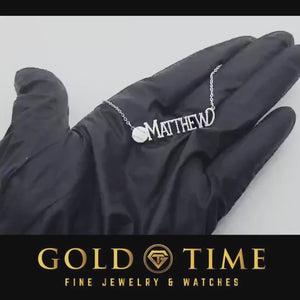 Video of a sterling silver baseball name necklace held in a gloved hand