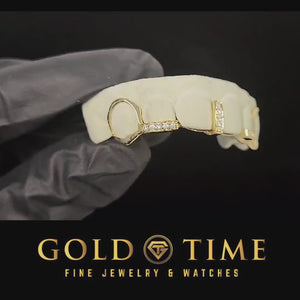 Video of the gold 5 piece open face fang grillz with moissanite gap bar turning on a dental model