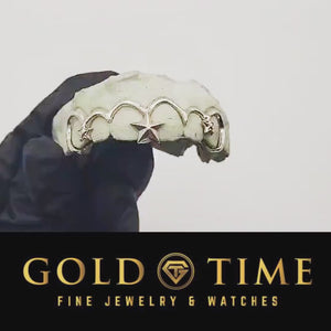 Video of silver frameless open face star grillz on a dental mold held in a black glove