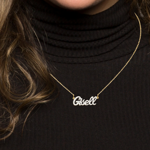 Woman in a black turtleneck wearing the Gisell two-tone diamond name necklace